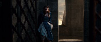 Movie still from “Beauty and the Beast” (2017), directed by Bill Condon – A woman standing in front of a stone wall; Wide shot, High angle