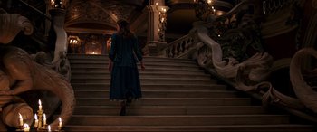Movie still from “Beauty and the Beast” (2017), directed by Bill Condon – A woman walking down a set of stairs; Wide shot, High angle