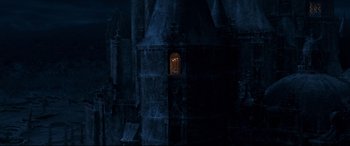 Movie still from “Beauty and the Beast” (2017), directed by Bill Condon – A dark building with a window and a door in it; Extreme Wide shot, High angle