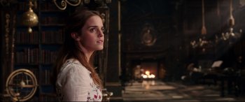 Movie still from “Beauty and the Beast” (2017), directed by Bill Condon – A woman standing in front of a fire place; Medium shot, Over the shoulder angle