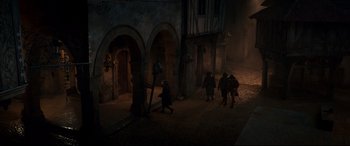 Movie still from “Beauty and the Beast” (2017), directed by Bill Condon – A group of people walking in a dark alley; Extreme Wide shot, High angle