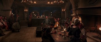 Movie still from “Beauty and the Beast” (2017), directed by Bill Condon – A group of people sitting at a table in a room; Wide shot, High angle