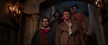 Movie still from “Beauty and the Beast” (2017), directed by Bill Condon – A group of men standing next to each other; Medium shot, Low angle