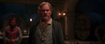 Movie still from “Beauty and the Beast” (2017), directed by Bill Condon – An old man with a beard and a mustache; Medium shot, Over the shoulder angle