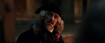 Movie still from “Beauty and the Beast” (2017), directed by Bill Condon – A man with a long beard wearing a hat; Close Up shot, Over the shoulder angle