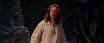 Movie still from “Beauty and the Beast” (2017), directed by Bill Condon – A man with long brown hair standing in front of a wall; Close Up shot, Low angle