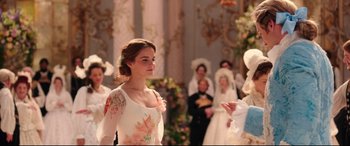 Movie still from “Beauty and the Beast” (2017), directed by Bill Condon – A beautiful young woman in a floral dress; Medium shot, Over the shoulder angle