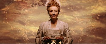 Movie still from “Beauty and the Beast” (2017), directed by Bill Condon – A woman in a white dress holding a cup; Medium shot, Overhead angle