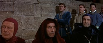 Movie still from “Becket” (1964), directed by Peter Glenville – Two men in medieval garb standing in front of a wall; Medium shot, Over the shoulder angle