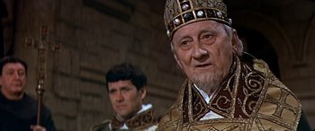 Movie still from “Becket” (1964), directed by Peter Glenville – A man in a suit and a man with a beard; Close Up shot, Over the shoulder angle