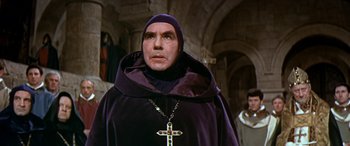 Movie still from “Becket” (1964), directed by Peter Glenville – A man wearing a purple robe and a cross necklace; Medium shot, Low angle
