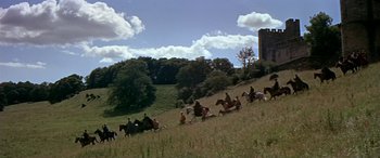 Movie still from “Becket” (1964), directed by Peter Glenville – A group of people riding horses down a grassy hill; Extreme Wide shot, High angle