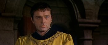 Movie still from “Becket” (1964), directed by Peter Glenville – A person wearing a yellow and black outfit; Close Up shot, Over the shoulder angle