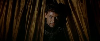 Movie still from “Becket” (1964), directed by Peter Glenville – A person in a room with a curtain; Medium shot, Low angle