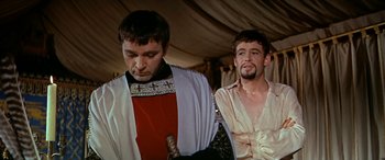 Movie still from “Becket” (1964), directed by Peter Glenville – Two men in medieval garb standing next to each other; Medium shot, Over the shoulder angle