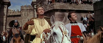 Movie still from “Becket” (1964), directed by Peter Glenville – A man wearing a crown standing next to a white horse; Medium shot, Low angle