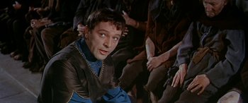 Movie still from “Becket” (1964), directed by Peter Glenville – A person sitting on the ground; Close Up shot, Over the shoulder angle