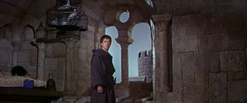 Movie still from “Becket” (1964), directed by Peter Glenville – A man in a robe standing in an archway of a castle; Wide shot, Low angle
