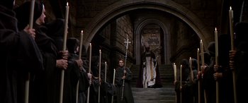 Movie still from “Becket” (1964), directed by Peter Glenville – A group of people standing in front of a building with candles; Wide shot, High angle