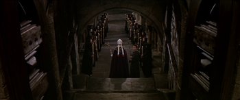 Movie still from “Becket” (1964), directed by Peter Glenville – A group of people standing in a hallway with candles; Extreme Wide shot, High angle