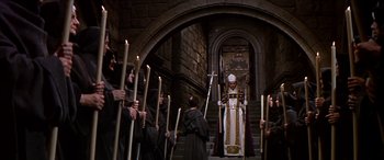 Movie still from “Becket” (1964), directed by Peter Glenville – A group of people holding lit candles in front of an archway; Wide shot, High angle