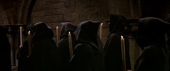Movie still from “Becket” (1964), directed by Peter Glenville – A group of people in hooded cloaks holding lit candles; Medium shot, High angle