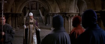 Movie still from “Becket” (1964), directed by Peter Glenville – A priest and two people in a castle; Wide shot, High angle