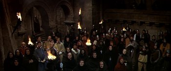 Movie still from “Becket” (1964), directed by Peter Glenville – A large group of people are gathered in front of a fire; Extreme Wide shot, High angle