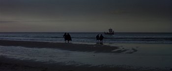 Movie still from “Becket” (1964), directed by Peter Glenville – A group of people walking on the beach at night; Extreme Wide shot, High angle