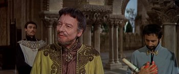 Movie still from “Becket” (1964), directed by Peter Glenville – An older man wearing a yellow and brown outfit; Medium shot, Over the shoulder angle
