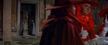 Movie still from “Becket” (1964), directed by Peter Glenville – A woman in a long red dress standing in front of a door; Wide shot, Over the shoulder angle