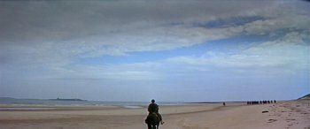 Movie still from “Becket” (1964), directed by Peter Glenville – A man riding a horse on the beach under a cloudy sky; Extreme Wide shot, High angle
