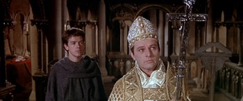 Movie still from “Becket” (1964), directed by Peter Glenville – Two men in medieval garb standing in front of a building; Medium shot, Low angle