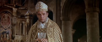 Movie still from “Becket” (1964), directed by Peter Glenville – A man in a priest's outfit is holding a glass; Close Up shot, Low angle