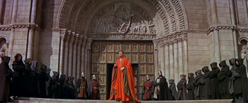 Movie still from “Becket” (1964), directed by Peter Glenville – A group of men standing in front of a building; Wide shot, Low angle
