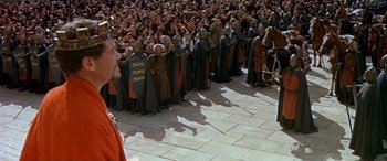 Movie still from “Becket” (1964), directed by Peter Glenville – A group of people standing next to each other on a sidewalk; Wide shot, High angle