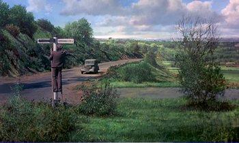 Movie still from “Bedknobs and Broomsticks” (1971), directed by Ward Kimball – A man standing on the side of a road next to trees; Wide shot, High angle