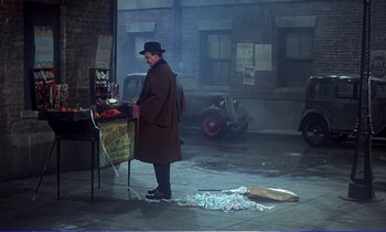 Movie still from “Bedknobs and Broomsticks” (1971), directed by Ward Kimball – A man in a brown coat and a black hat; Wide shot, High angle