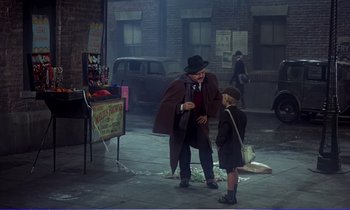 Movie still from “Bedknobs and Broomsticks” (1971), directed by Ward Kimball – A man and a child in a street; Wide shot, Over the shoulder angle