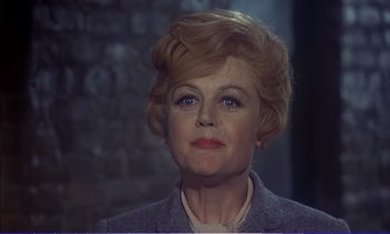 Movie still from “Bedknobs and Broomsticks” (1971), directed by Ward Kimball – An older woman wearing a jacket and a sweater; Close Up shot, Low angle