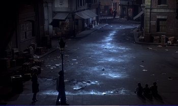 Movie still from “Bedknobs and Broomsticks” (1971), directed by Ward Kimball – A city street at night lit by street lamps; Extreme Wide shot, High angle