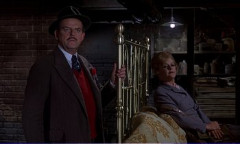 Movie still from “Bedknobs and Broomsticks” (1971), directed by Ward Kimball – An older man and a woman in a room; Medium shot, Low angle