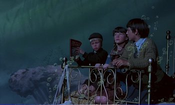 Movie still from “Bedknobs and Broomsticks” (1971), directed by Ward Kimball – A group of children sitting on a balcony reading; Wide shot, High angle