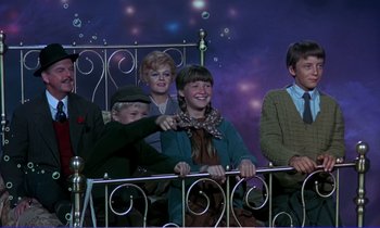 Movie still from “Bedknobs and Broomsticks” (1971), directed by Ward Kimball – A group of people sitting next to each other on top of a bed; Medium shot, High angle