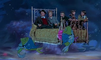 Movie still from “Bedknobs and Broomsticks” (1971), directed by Ward Kimball – A group of people sitting on a bed in the middle of the night; Wide shot, High angle
