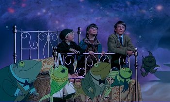 Movie still from “Bedknobs and Broomsticks” (1971), directed by Ward Kimball – A group of people sitting on top of a bed next to each other; Wide shot, High angle