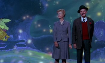 Movie still from “Bedknobs and Broomsticks” (1971), directed by Ward Kimball – A man and a woman standing next to each other; Wide shot, Low angle