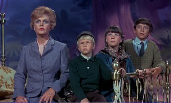 Movie still from “Bedknobs and Broomsticks” (1971), directed by Ward Kimball – A group of people sitting next to each other on a stage; Medium shot, Low angle