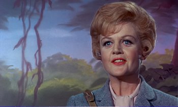 Movie still from “Bedknobs and Broomsticks” (1971), directed by Ward Kimball – An older woman with blonde ringlet hair and blue eyes in front of a painting; Close Up shot, Low angle