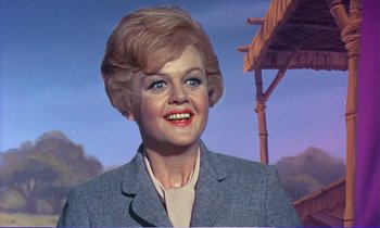 Movie still from “Bedknobs and Broomsticks” (1971), directed by Ward Kimball – A woman with blonde hair wearing a gray jacket; Close Up shot, Low angle
